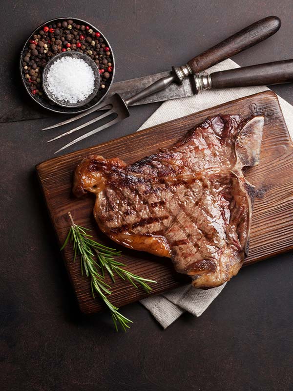 T bone steak garnished with a side of asparagus and salt & pepper at Blackstone Grille in Chattanooga, TN