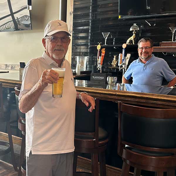 Restaurant guest at Blackstone Grille tavern and bar in Chattanooga, Tennessee holds up an ice cold tap beer